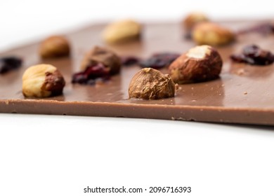 Hand Crafted Milk Chocolate With Hazelnuts, Raisins And Dried Fruits On White Background. Selective Focus
