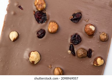 Hand Crafted Milk Chocolate With Hazelnuts, Raisins And Dried Fruits On White Background. Selective Focus