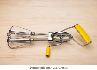 Hand Crank Egg Beaters with yellow handle.