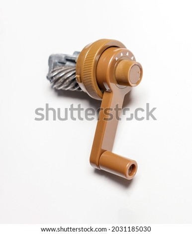 hand cranked pencil sharpener core isolated on a white backdrop 