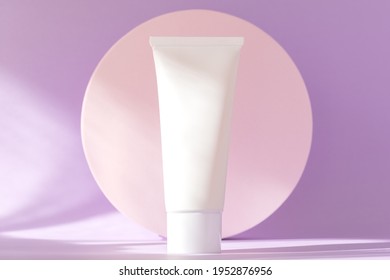 Hand cream, moisturizer, lotion jar plastic tube on background with natural shadows, high angle view. Skin care cosmetic bottle mockup on lilac podium. Brand spa packaging mock up. Branding identity