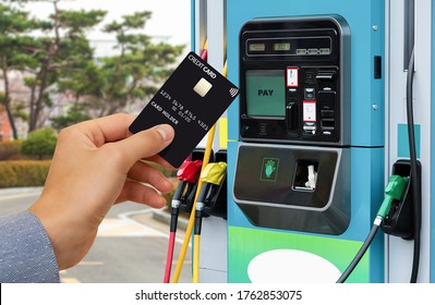 Hand With A Credit Card On The Background Of A Self-service Gas Station. Contactless NFC Payment 