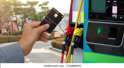 Hand With A Credit Card On The Background Of A Self-service Gas Station. Contactless NFC Payment 