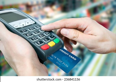 Hand With Credit Card Swipe Through Terminal For Sale In Supermarket