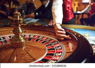 Hand Of A Croupier On A Roulette Whell In A Casino.