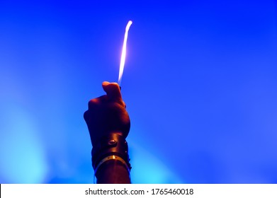 Hand From The Crowd At A Music Festival With A Burning Lighter. The Romance And Atmosphere Of A Rock Band Concert. Fan At A Concert