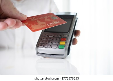 Hand Of Customer Paying With Contactless Credit Card With NFC Technology.