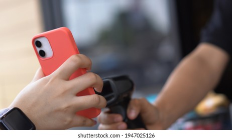 Hand Of Customers In The Car Using Mobile Phone Pay For Food Or Drinks. Salesperson Is Using A Barcode Reader To Accept Payment. Driving Through Or Drive Thru Concept.