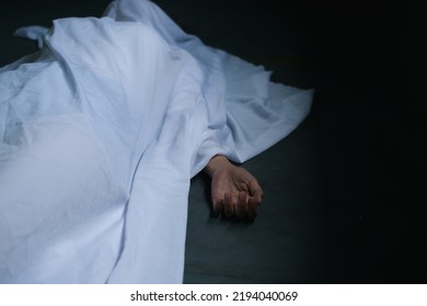 Hand of dead woman lying down under white cloth covered death body from murder at house of victim,Horror and crime scene. - Shutterstock ID 2194040069