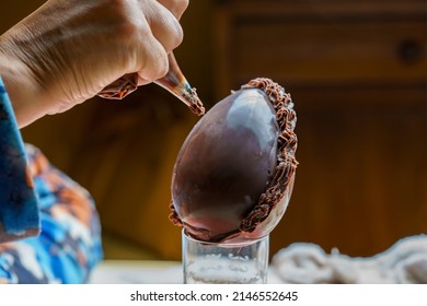 Hand Decorating A Chocolate Easter Egg With A Pastry Bag