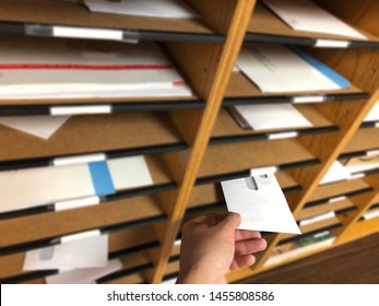 Man´s Hand Delivering & Receiving Mail From A Mailbox Sorter Inside The Office.