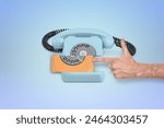 Hand dialing a retro orange rotary phone