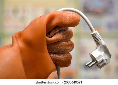 A Hand In A Dielectric Glove Holds A Wire With A Socket.