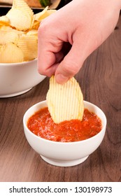 Hand Dipper Potato Chips In The Salsa Sauce