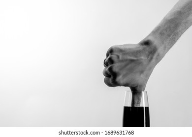 The hand dips its thumb into glass black liquid  Minimalism  Black   white photo  Copy space  Dislike  Thumbs down