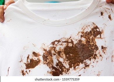 Hand With Dirty Shirt, Children Shirt With Chocolate Stains.