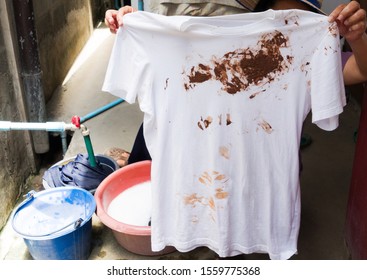 Hand With Dirty Shirt, Children Shirt With Chocolate Stains.