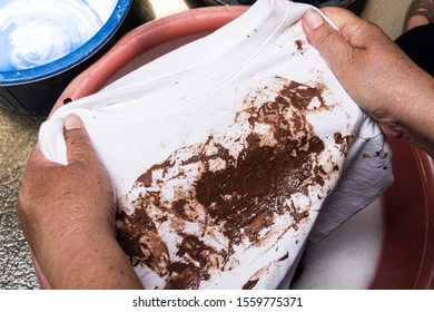 Hand With Dirty Shirt, Children Shirt With Chocolate Stains.