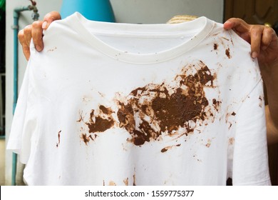 Hand With Dirty Shirt, Children Shirt With Chocolate Stains.