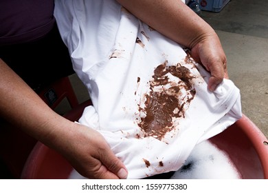 Hand With Dirty Shirt, Children Shirt With Chocolate Stains.