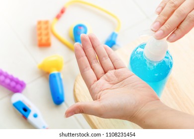 Hand  disinfection concept. Closeup female hand using sanitizer bottle against toy background. Alcohol gel protection hands from disease,virus and bacteria in lifestyle.  - Powered by Shutterstock