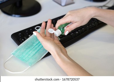 Hand Disinfection At The Workplace In The Office. Female Hands Squeeze A Hand Sanitizer Gel From Bottle. Office Corona Virus Protection