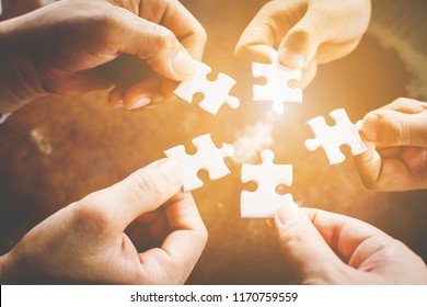 Hand of diverse people connecting jigsaw puzzle. Concept of partnership and teamwork in business - Powered by Shutterstock