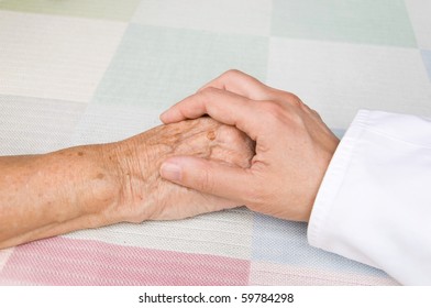 hand of a doctor holding the hand of an elderly patient