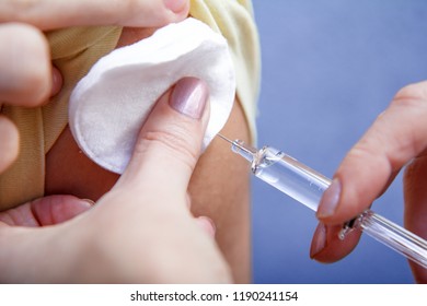 Main du médecin tenant une seringue pour la vaccination au bras supérieur du patient pour la prévention de la maladie de la grippe. Mise au point sélective sur la seringue