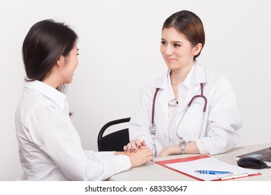 Hand Of Doctor Reassuring Her Female Patient In The Consulting Room.