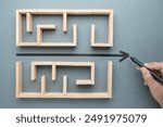 Hand draw a shorten straight line to go through the complication of a maze game, built by wood blocks, shorten process, simplify, and communication concept