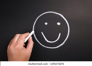 Hand Draw A Smile Face On Chalkboard For Satisfaction Concept
