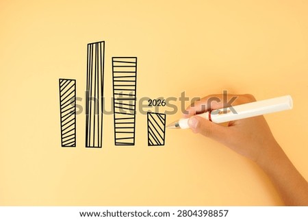 Hand drawing a bar chart with a declining 2026 value on a pastel background. Concept of business slowdown, revenue decline, economic challenges and financial performance.