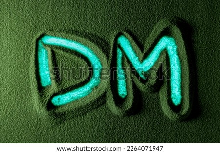 Hand drawing the Deutsche Mark currency symbol in the Green Sand. Male hand writes the Deutsche Mark currency symbol on the green sand with blue backlight. Top view 4k resolution