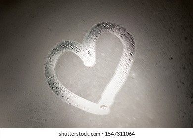 Hand Drawing Heart Symbol On Foggy Mirror