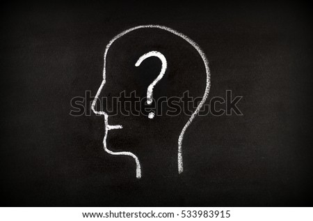 Hand drawing human head shape with chalk  on blackboard and question mark