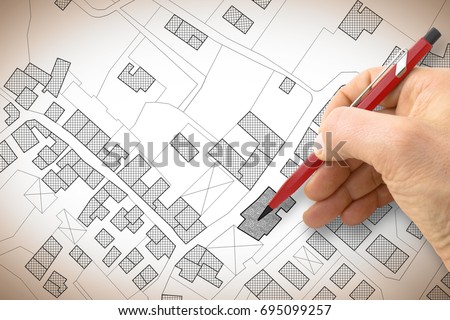 Hand drawing an imaginary cadastral map of territory with buildings and roads