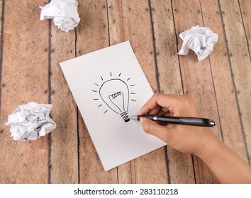 Hand Drawing Light Bulb On A Note Pad. Concept For Idea, Creativity, Imagination And Perserverance