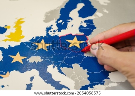 Hand drawing a red line between Poland and the rest of EU, Polexit concept.