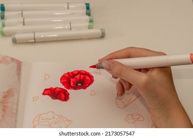 Hand Drawing A Red Poppy Wreath Sketch In A Sketchbook With Alcohol Based Sketch Drawing Markers. Remembrance Day And Anzac Day.