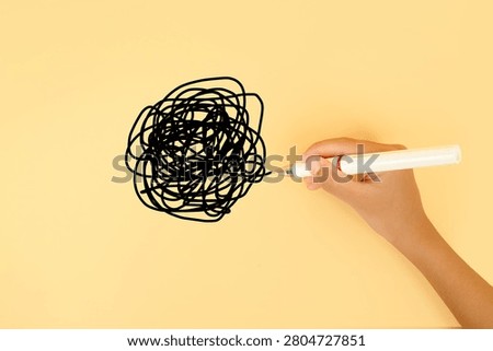 Hand drawing a tangled scribble on a pastel background. Concept of confusion, stress, overthinking, mental clutter, problem solving and chaotic thoughts.