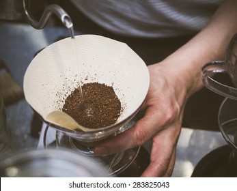 Hand drip coffee, Barista pouring water on coffee ground with filter 