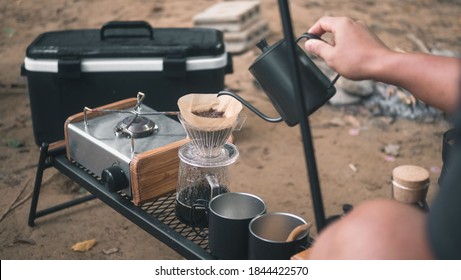 Hand drip coffee in the camp, A man pouring water on coffee ground with filter.Drip coffee and camping. - Powered by Shutterstock