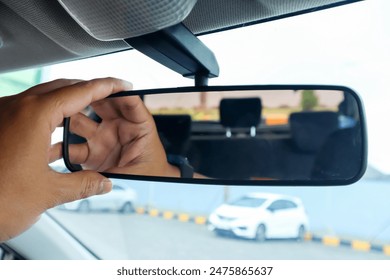 Hand of driver adjusting rear view mirror of car. Trip, journey and safety riding concept - Powered by Shutterstock