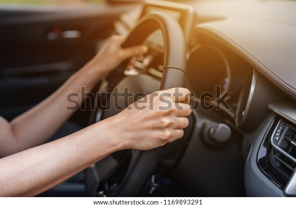 hand driving on\
steering wheel in a car