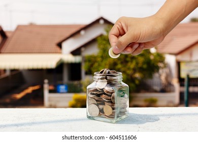 A Hand Is Dropping A Coin Into A Bottle, Home Saving Concept