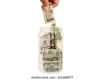 Hand Dropping Five Dollar Bill Into Container Full Of US Currency Money Isolated On White Background