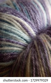 Hand dyed hank skeing ball of yarn wool.  Shallow depth of field.  Lilac, blue and white colour