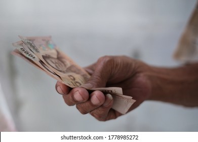 Hand Of Elderly Man Holding 3,000 Baht Thai Banknotes. Old People Get Relief Monetary Fund From Government As Covid-19 Spreading. Elderly Man Holding Cash / Relief Fund / Saving Money Concept.