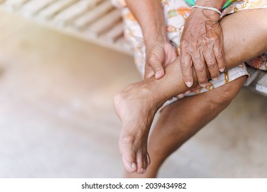 Hand of an elderly woman massaging an ankle with an injury due to arthritis, osteoporosis, tendon injury. Concept of sickness in the elderly.